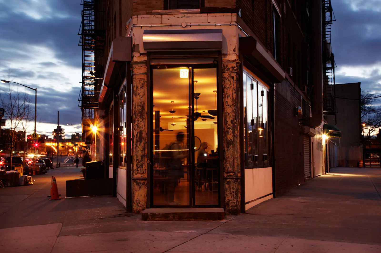Beleuchtetes Eckrestaurant an einer Straßenkreuzung in Williamsburg in der Abenddämmerung