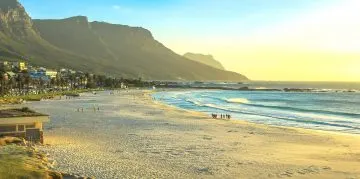 Weiter Sandstrand von Camps Bay im Abendlicht vor den Twelve Apostles