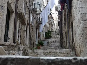 Steile Treppengasse in der Altstadt von Dubrovnik mit aufgehängter weißer Wäsche