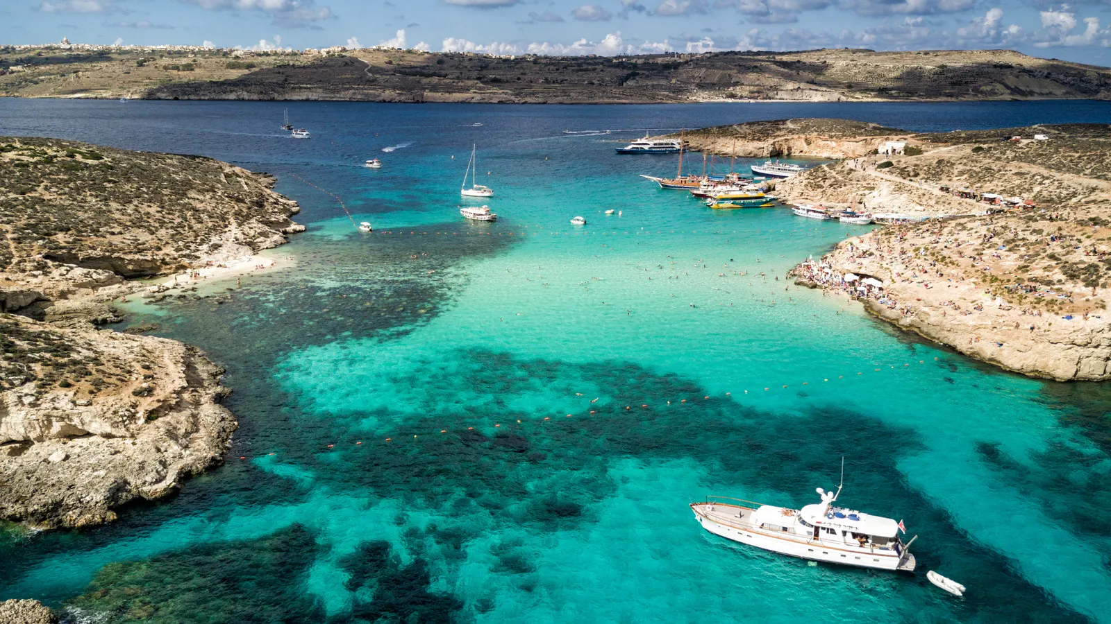 Türkisblaues Wasser und Boote in der Blauen Lagune auf Comino, Malta