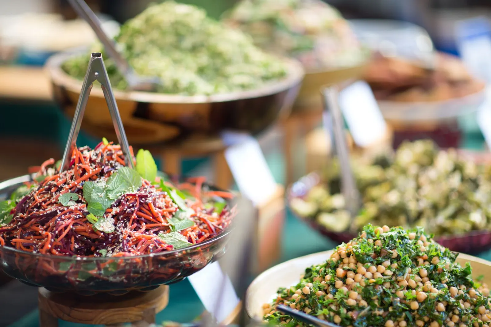 Schalen mit Rohkostsalaten, Rote-Bete-Streifen und Kichererbsen-Grünkohl am Buffet des Neighbourgoods Market