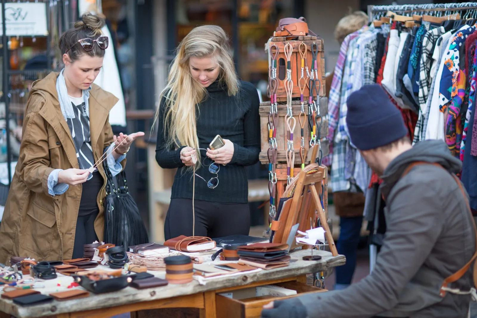 Zwei Frauen betrachten Ledertaschen und Gürtel an einem Stand des Neighbourgoods Market