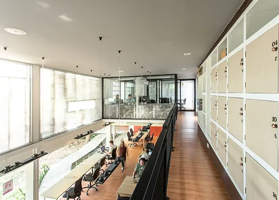 Blick von der Galerie über nummerierte Schließfächer auf die Arbeitsplätze im Erdgeschoss