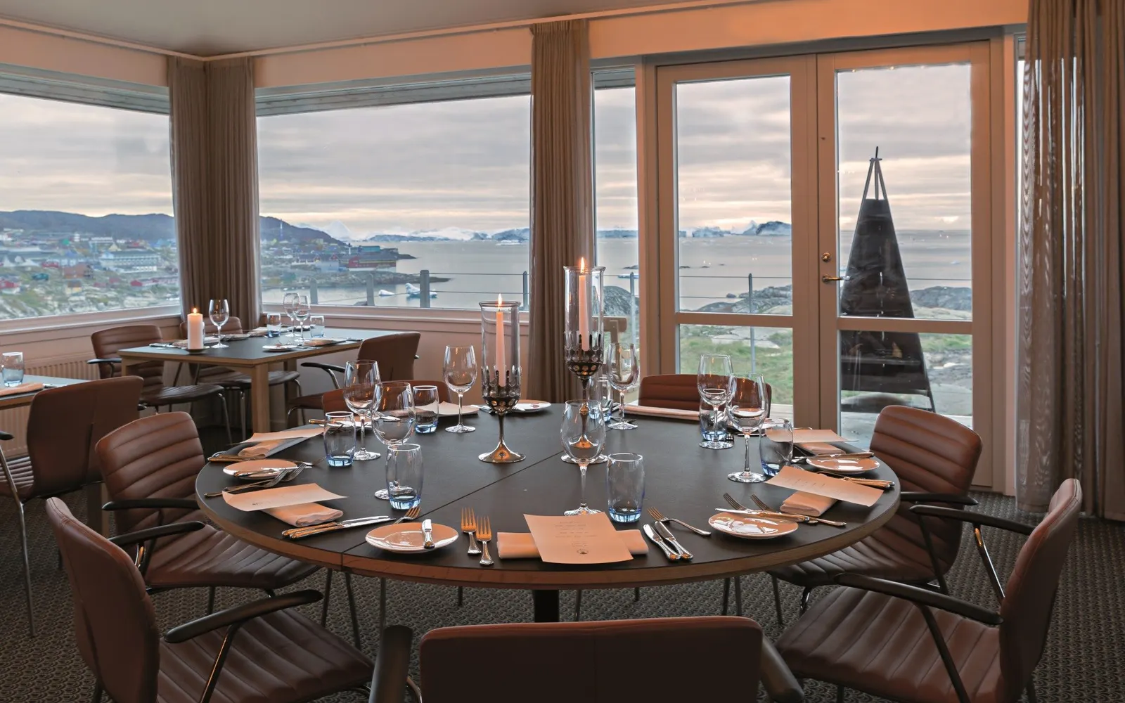 Runder gedeckter Tisch mit Kerzenleuchter am Panoramafenster, Blick über Nuuk und den Fjord