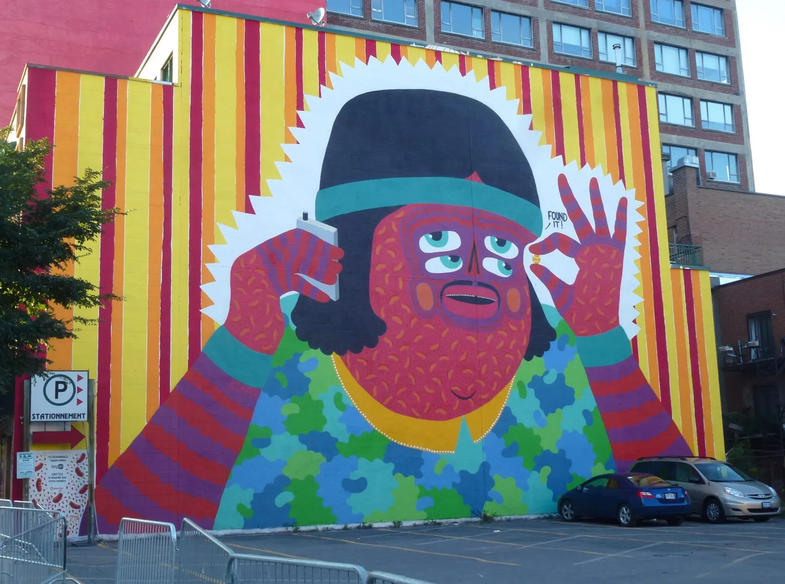 Großes buntes Wandbild an einer Hausfassade, Figur mit vier Augen und Bart
