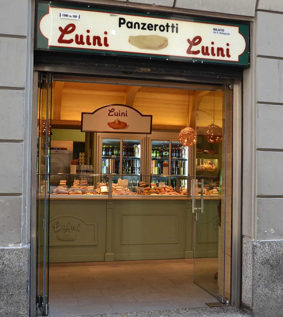 Eingang von Luini mit beleuchteter Auslage voller Panzerotti hinter der Theke