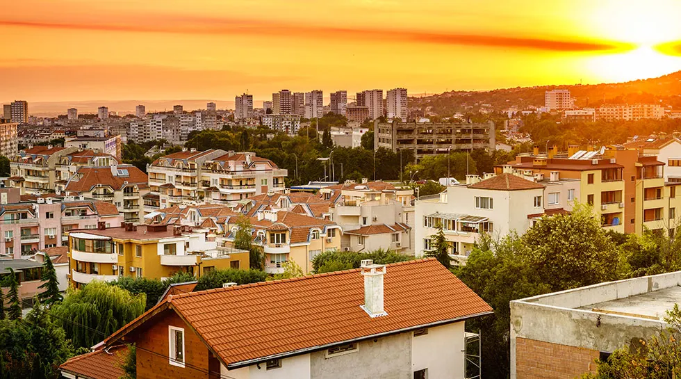 Blick über die Dächer und Wohnhäuser von Varna bei orangefarbenem Sonnenuntergang